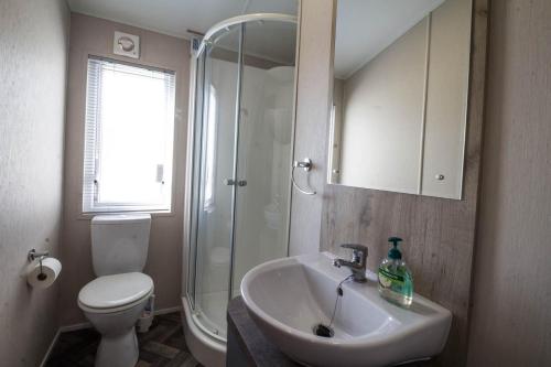 a bathroom with a sink and a shower and a toilet at Beautiful 8 Berth Lodge For Hire At Kessingland Beach In Suffolk Ref 90012td in Benacre