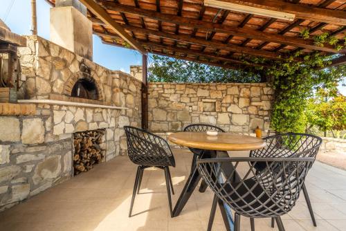 an outdoor patio with a wooden table and chairs at Villa Olive with Pool & SeaView in Agia Pelagia