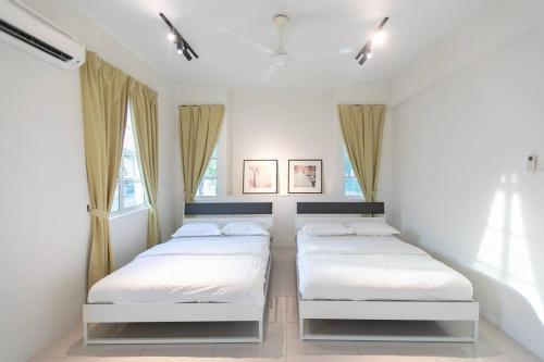 two beds in a room with two windows at Penang Balik Pulau Swimming Pool BBQ Homestay in Balik Pulau