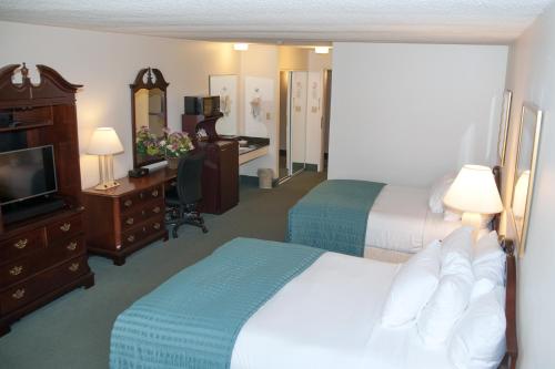 Cette chambre comprend deux lits et une télévision. dans l'établissement River Terrace Inn, à Green River