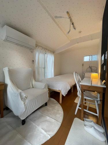 a room with two beds and a chair and a desk at 経堂の小さなお部屋cottu in Tokyo