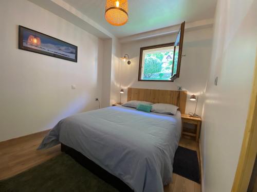 une petite chambre avec un lit et une fenêtre dans l'établissement Appartement au calme avec vue sur les montagnes., à Sévrier