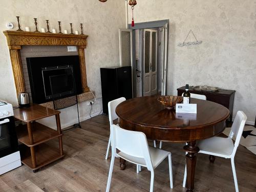 a dining room with a table and chairs and a fireplace at Casale storico Enzo in Castelnuovo del Garda