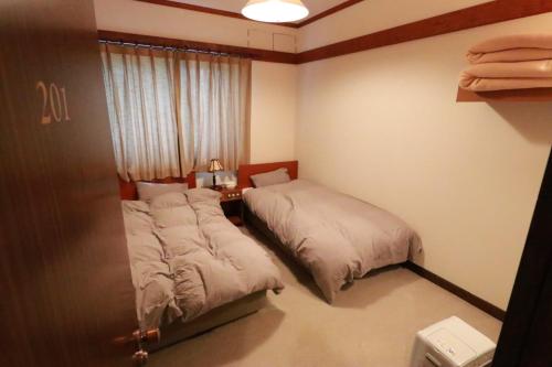 a bedroom with two beds and a window at Larix Tateshina Villa - Vacation STAY 86531v in Chino