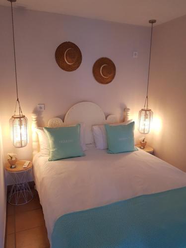 una camera da letto con un grande letto bianco con due luci di Ferienwohnung MOMENTE a Waldbreitbach