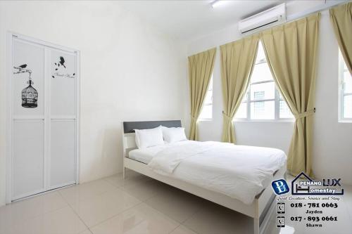 Habitación blanca con cama y ventana en Balik Pulau 6BR Comfort Home Villa, en Balik Pulau