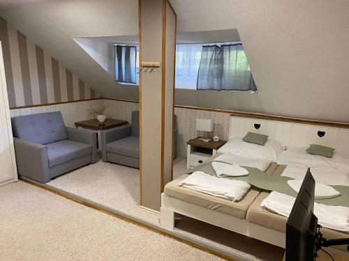a mirror reflecting a bedroom with a bed and a chair at Penzion Zákoutí in Pec pod Sněžkou