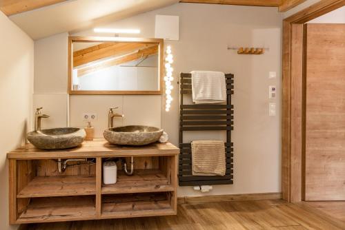 uma casa de banho com 2 lavatórios e um espelho em Piekvier lodge em Schladming