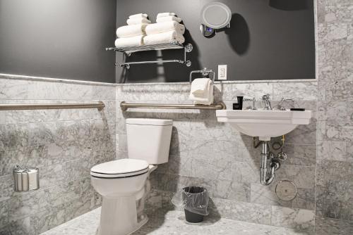 een badkamer met een toilet, een wastafel en handdoeken bij St. Clair Inn 