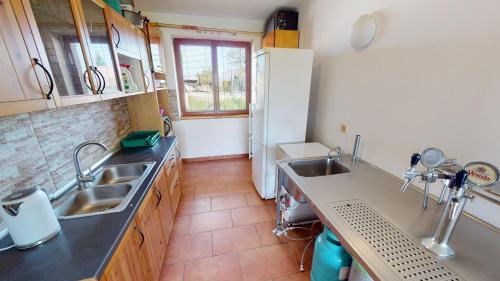 a kitchen with two sinks and a refrigerator at U MIRASE Heřmaničky in Heřmaničky