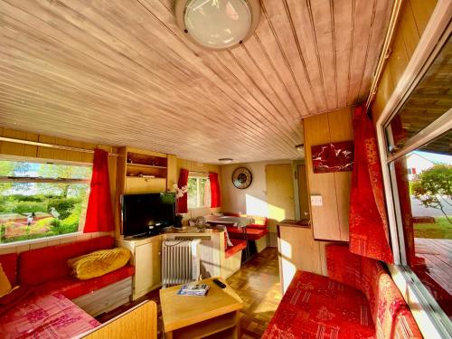 a room with a living room and a kitchen in a rv at Mobilhome sous chalet en bois au calme à la ferme in Josnes