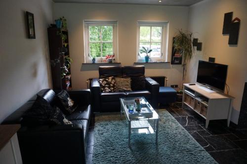 a living room with a couch and a coffee table at Guesthouse Rijsbergen_Zundert in Zundert