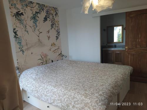 - une chambre avec un lit et un papier peint floral dans l'établissement la maison de josy, à Aix-en-Provence