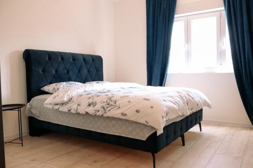 a bed with a blue headboard in a bedroom at Sunny House in Čapljina