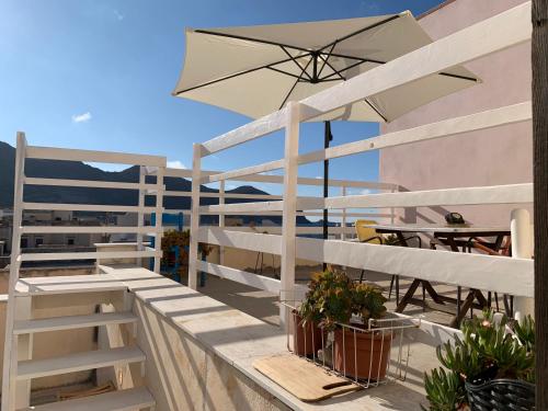 balcone con ombrellone, tavoli e sedie di Al centro del centro - Favignana a Favignana