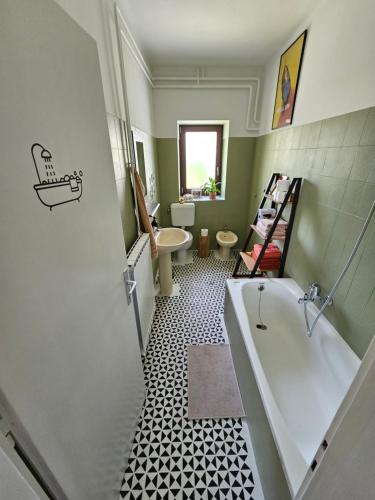 a bathroom with a tub and a toilet and a sink at The Green Door Apartment in Postojna
