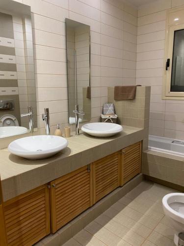 La salle de bains est pourvue de 2 lavabos et de toilettes. dans l'établissement Villa Olivetti, à Anavyssos