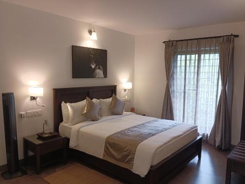a bedroom with a large bed and a window at Dvara Luxury Resort Kodaikanal in Kodaikānāl