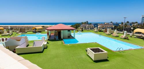 een groot zwembad met stoelen en een resort bij The House of Nonni Ventura - beachfront, ocean view, Wi-Fi, aircon, swimming pool in Morro del Jable