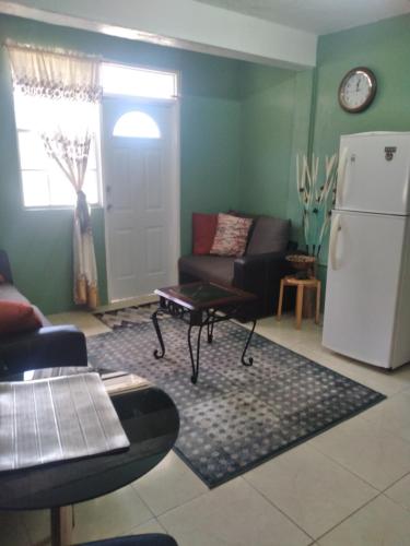 a living room with a couch and a refrigerator at Ebenezer's Haven in Roseau