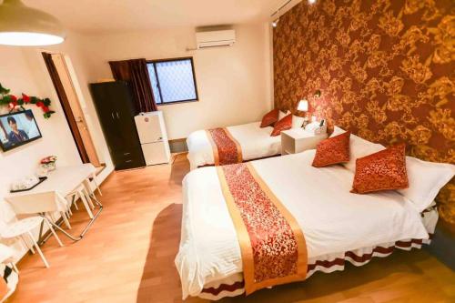 a hotel room with two beds and a table and chairs at 可容13人106平独栋别墅机场33分钟直达离難波心斎橋道顿堀做地下铁5分钟3个独立卧室都带有私人干湿分离智能马桶 淋浴房洗面台3卫3浴3洗面台 in Osaka