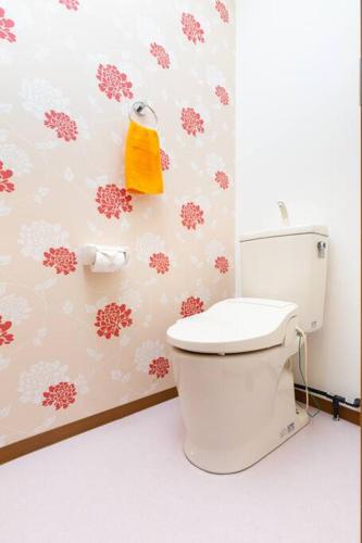 a bathroom with a toilet and a yellow towel on the wall at 可容13人106平独栋别墅机场33分钟直达离難波心斎橋道顿堀做地下铁5分钟3个独立卧室都带有私人干湿分离智能马桶 淋浴房洗面台3卫3浴3洗面台 in Osaka