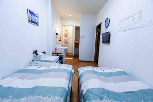 a room with two beds and a hallway at 可容13人106平独栋别墅机场33分钟直达离難波心斎橋道顿堀做地下铁5分钟3个独立卧室都带有私人干湿分离智能马桶 淋浴房洗面台3卫3浴3洗面台 in Osaka