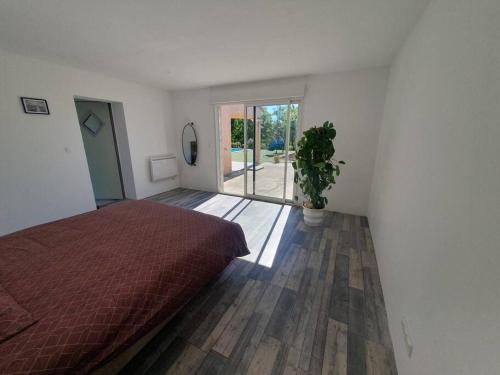 a bedroom with a bed and a potted plant at AC Interlude in Castelnau-de-Montmiral
