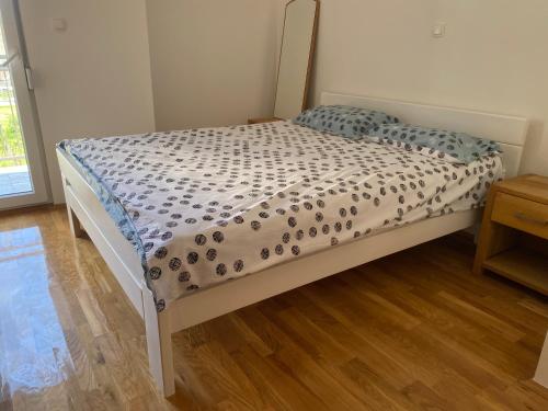 a bed in a room with a wooden floor at Apartment 28 in Ljubuški
