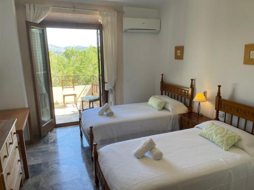 two beds in a room with a view of a balcony at Villa Florida Luxury Villa with huge pool in Pollença