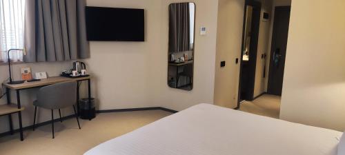 a hotel room with a bed and a table and a desk at Silken Ciudad Gijón in Gijón