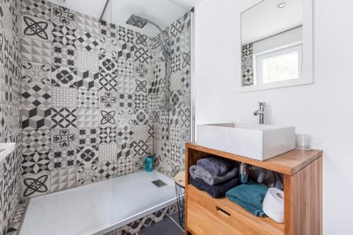 ein Bad mit einer Badewanne, einem Waschbecken und einer Dusche in der Unterkunft L'Ethnique in Liévin