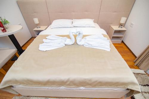 a bed with towels on it in a room at Hotel Konačište Akustik in Zlatibor