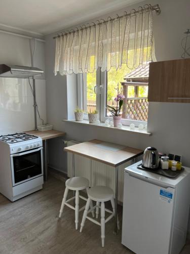 a kitchen with a stove and a counter with stools at Apartament Kackówka in Gdynia