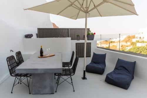 d'une table, de chaises et d'un parasol sur le balcon. dans l'établissement Afora Houses, à Vóthon