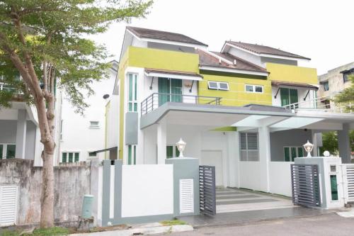 una casa gialla e bianca con una recinzione di Teluk Bahang European Style SemiD 4 Bedrooms 10ppl a Teluk Bahang