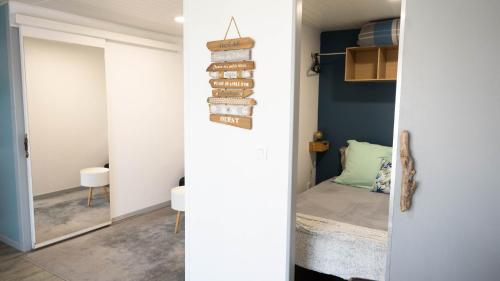 um quarto com paredes azuis e uma porta com um espelho em studio 2 étoiles em Mimizan