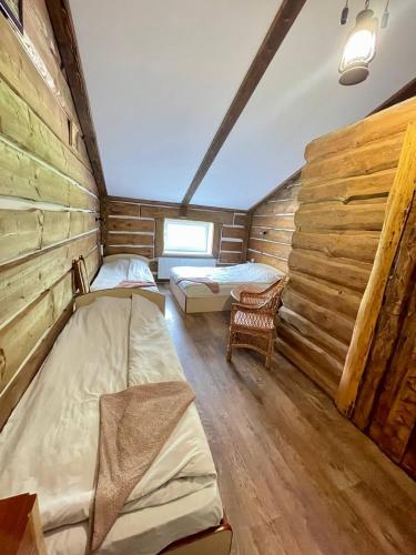a room with two beds in a log cabin at Hotel Mlyn in Nikolayev