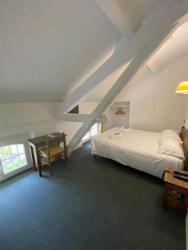 a bedroom with a bed and a desk and a staircase at HOTEL ST SEBASTIEN in Roquebillière