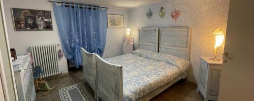 una camera con letto e tenda blu di LA CASA DI PUCCI nel borgo affrescato di PARLASCO a Cortenova
