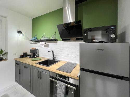 a kitchen with a stainless steel refrigerator and green walls at SOS CoMFORT 2 LAZUR in Burgas