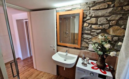 ein Badezimmer mit einem Waschbecken und einer Steinmauer in der Unterkunft La Mimosa - Bike Friendly Home in Rosignano Solvay