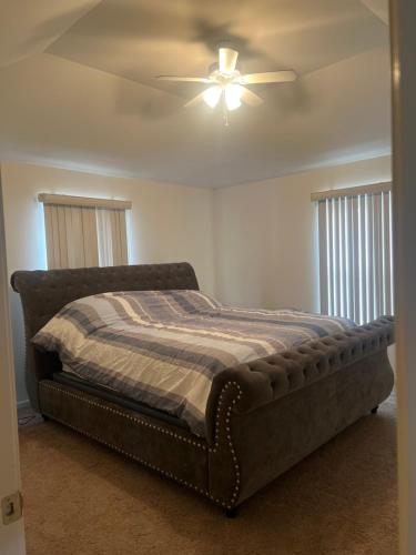 a bedroom with a bed with a ceiling fan at Luxury apartment in suburbs in Sterling Heights