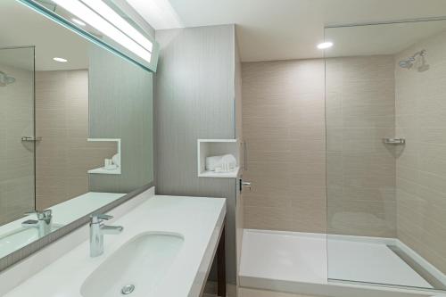 ハリファックスにあるCourtyard by Marriott Halifax Dartmouthのバスルーム(洗面台、ガラス張りのシャワー付)