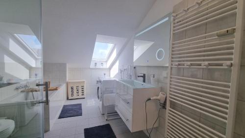 Wohnung: Workaholic bis 6 Personen, Klima, 3x TV في Cremlingen: حمام أبيض مع حوض ومرآة