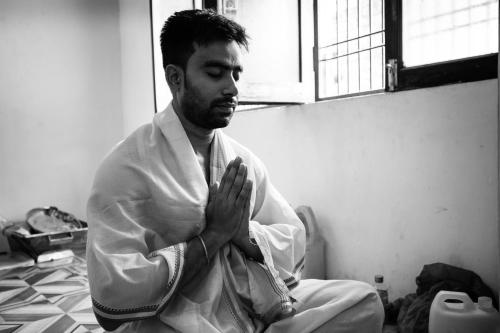 a man sitting on the floor in a room at Somit Paying Guest House in Varanasi