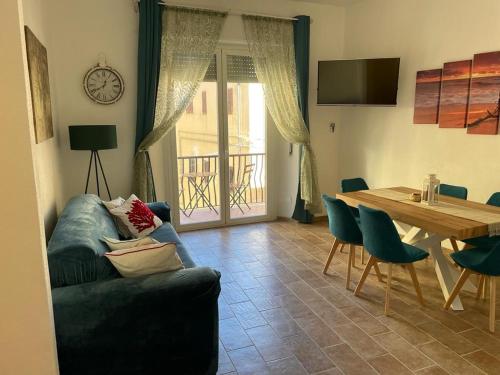 uma sala de estar com um sofá e uma mesa com cadeiras em Maddy house - 50 mt dal mare em Porto Santo Stefano