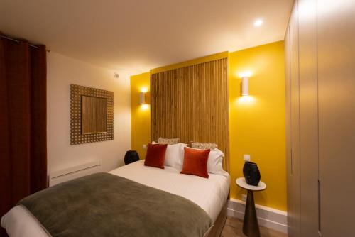 1 dormitorio con 1 cama grande con almohadas de color naranja en Au pied de la Tour, en París