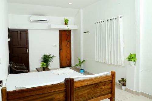 a bedroom with a bed and a room with plants at Bethesda Inn in Cochin