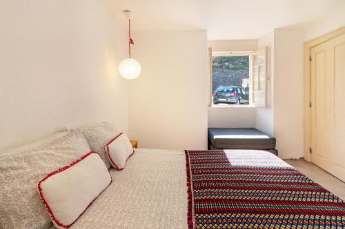 a bedroom with a large bed and a window at Calheta Beach House T2 in Calheta